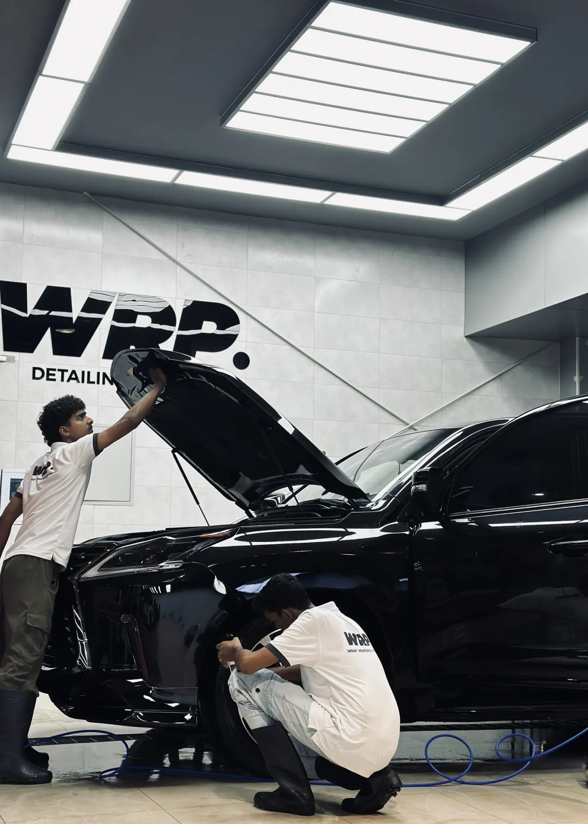 WRP Detailing Studio technician applying professional ceramic coating on Lexus luxury vehicle hood