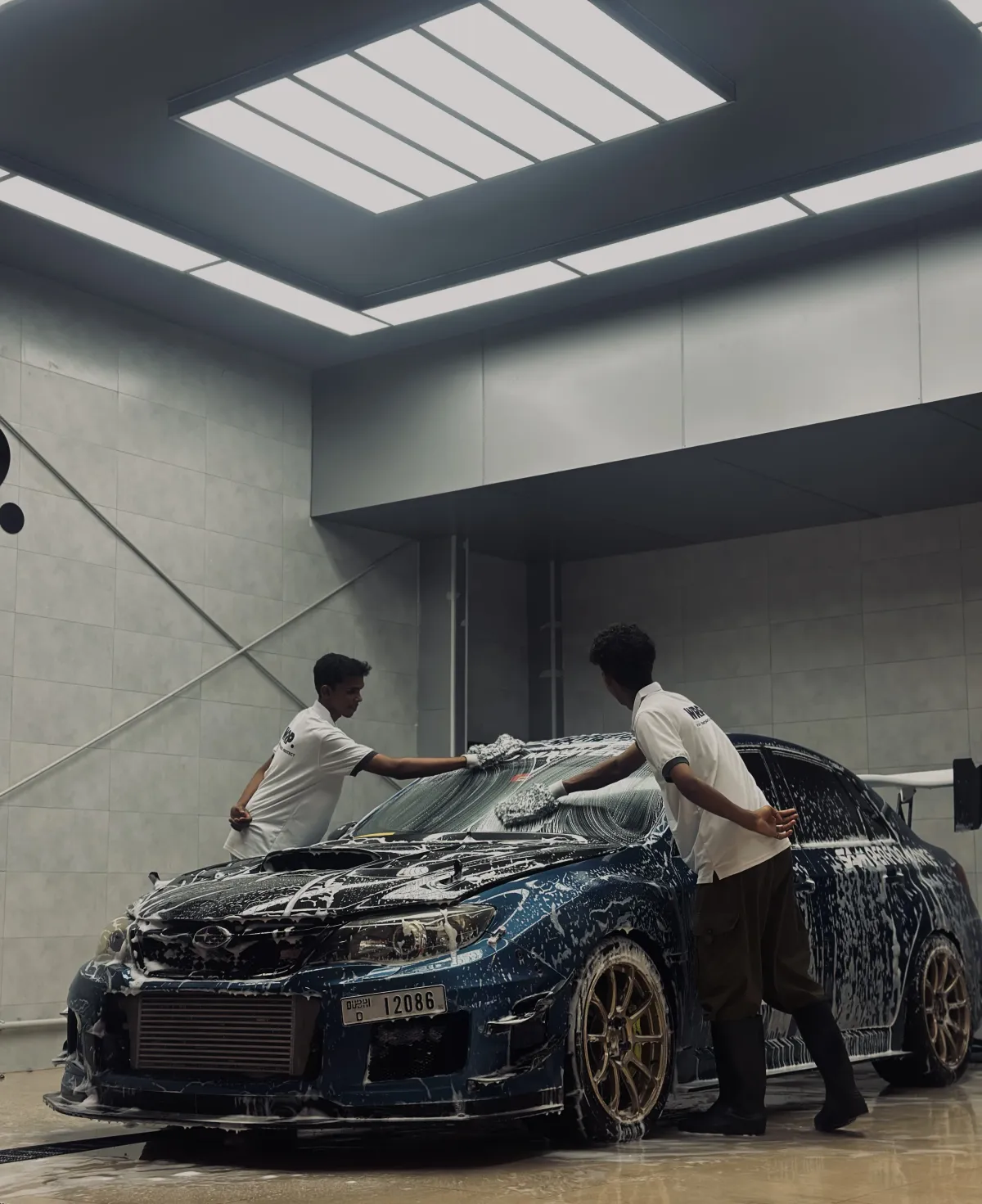 WRP Detailing Studio team performing premium hand car wash with foam treatment on Subaru WRX STI